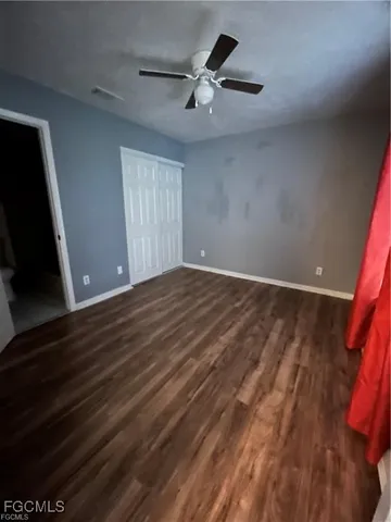 a view of room with a ceiling fan and wooden floor