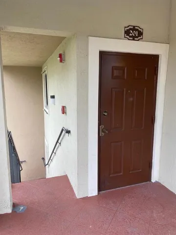 a view of a hallway to a house with wooden floor and stairs