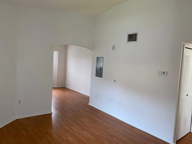 a view of an empty room with wooden floor