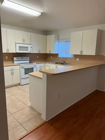 a kitchen with a sink window and cabinets