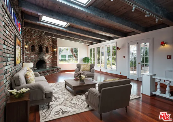 a living room with fireplace furniture and a large window