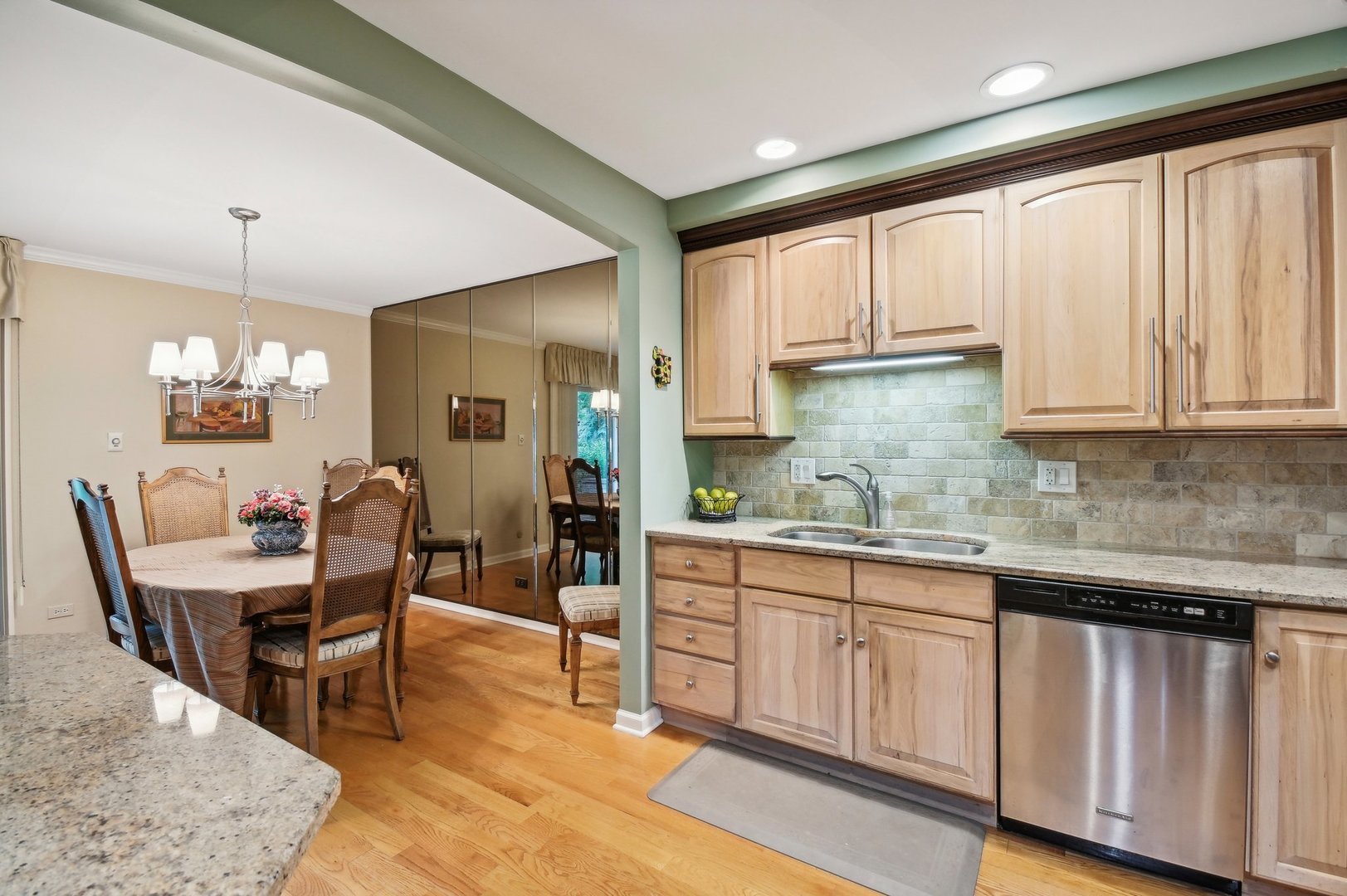 1551 Winnetka Road Glenview, IL 60025 - Photo 5 of 28 a kitchen with stainless steel appliances kitchen island granite countertop a table chairs sink and cabinets