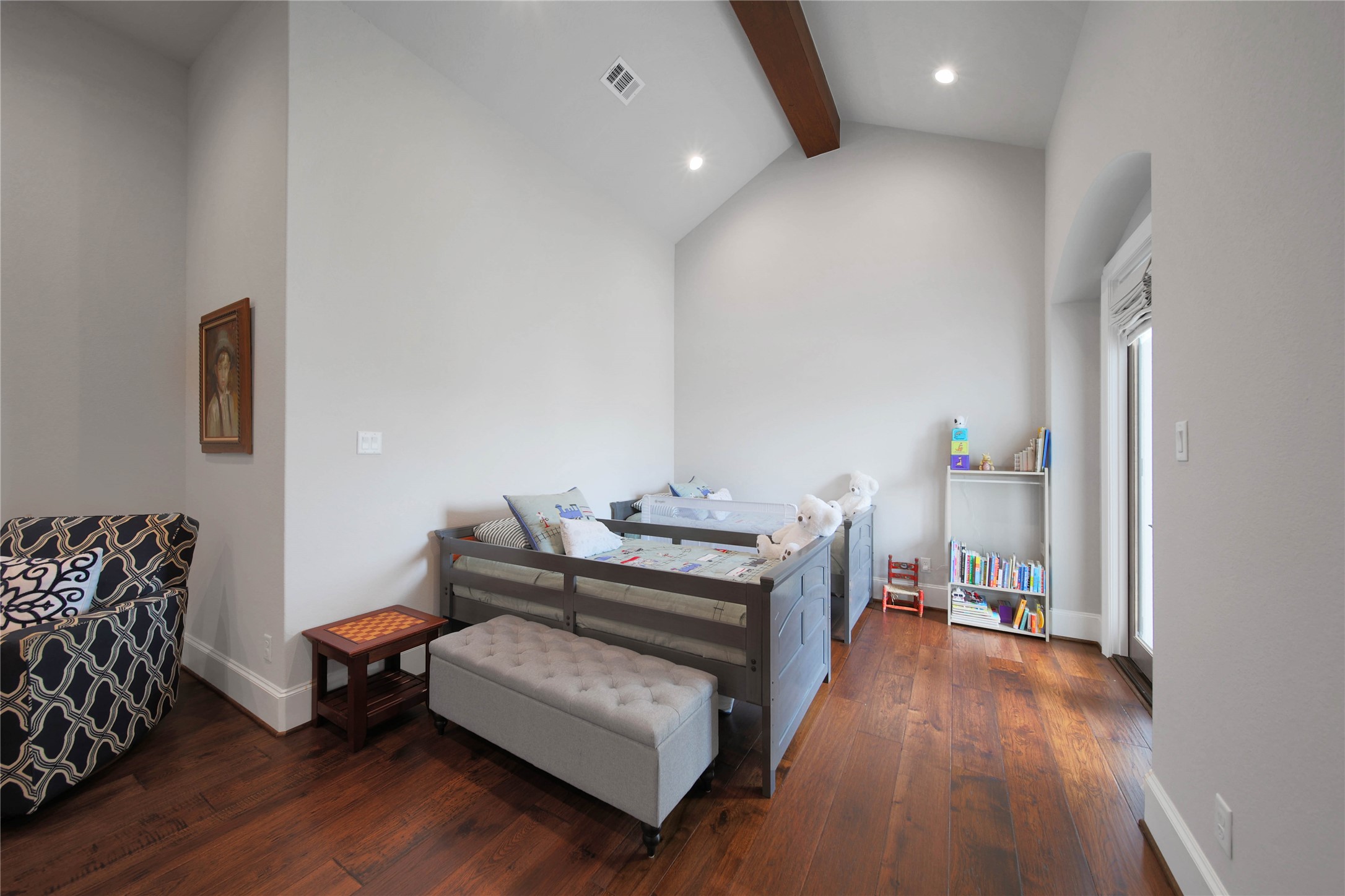 24718 Shadow Pond Spring, TX 77389 - Photo 28 of 49 Charming bedroom with high ceilings and warm hardwood floors, featuring a cozy reading nook and ample natural light from a large window.