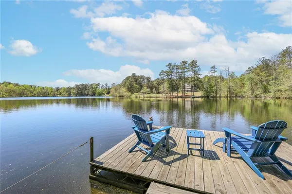 a view of a lake with a table and chairs next to a lake
