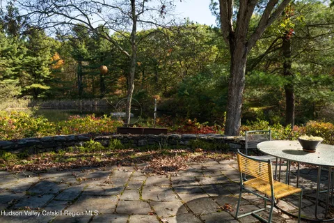 a view of a house with a yard plants and large tree