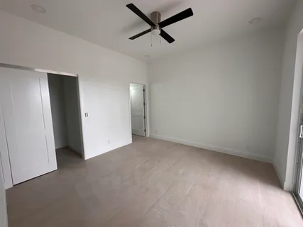 an empty room with a ceiling fan and window