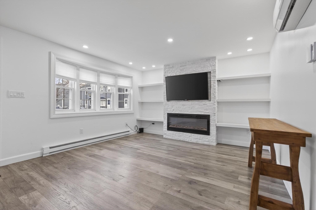 15 Cedar Square, Unit 15 Millis, MA 02054 - Photo 8 of 42 a view of a livingroom with furniture a fireplace and wooden floor