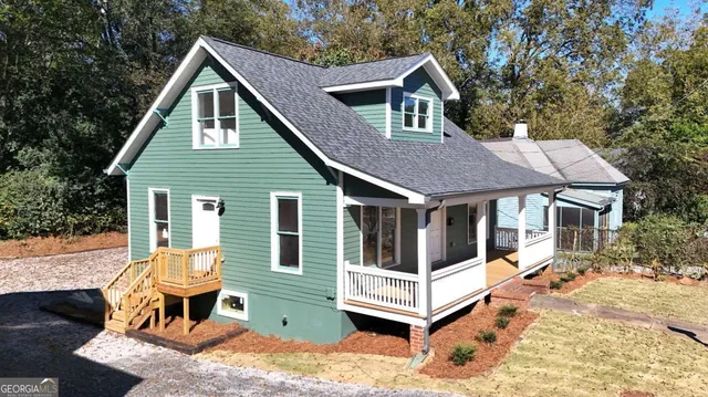 a view of a house with a yard and wooden deck