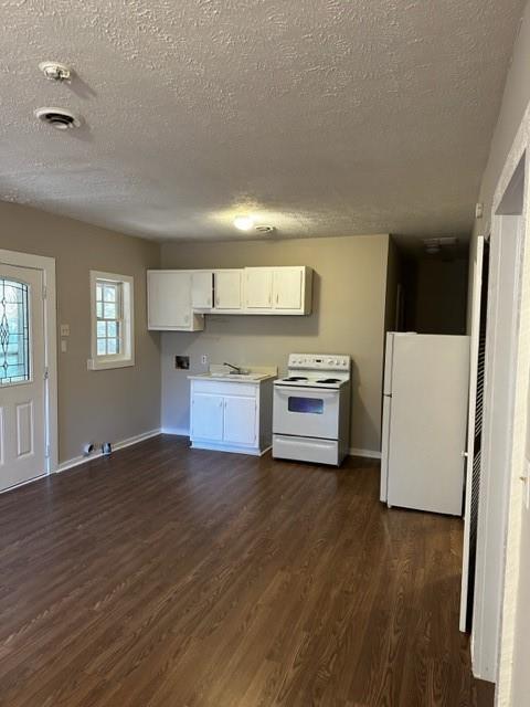a view of a kitchen with a sink stove cabinets and empty room