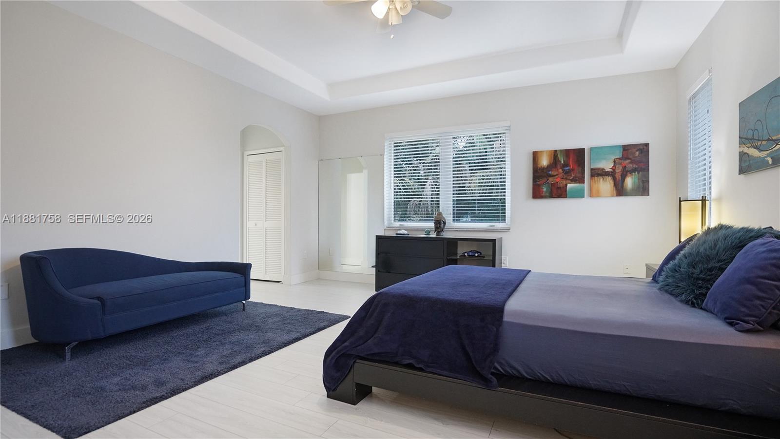 704 Northwest 129th Court Miami, FL 33182 - Photo 32 of 58 a spacious bedroom with a bed a couch and a chandelier