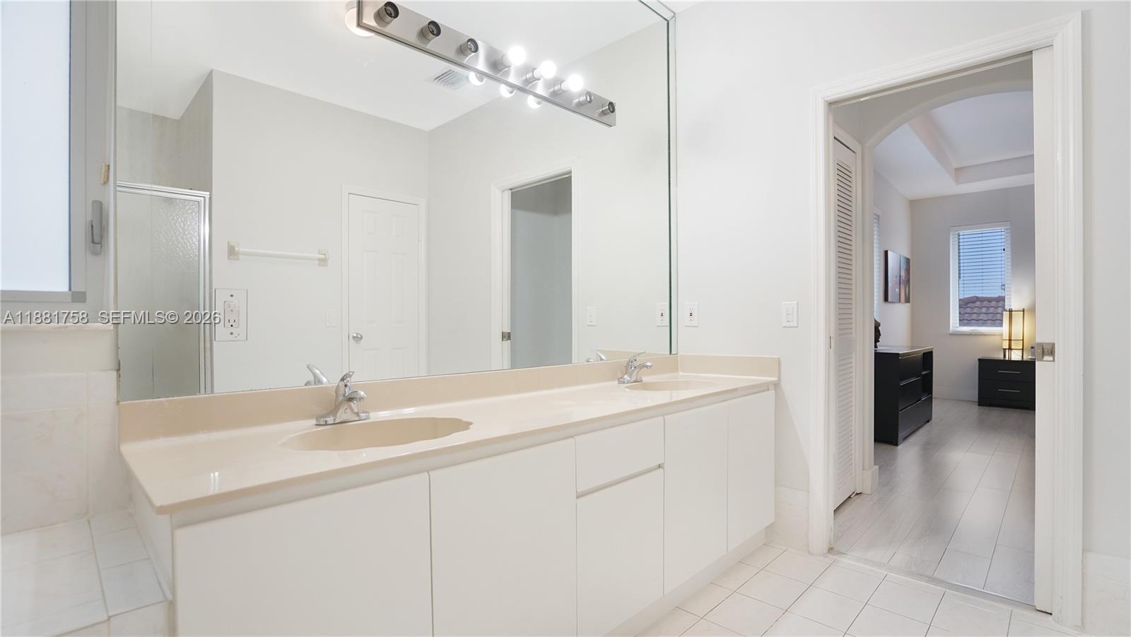 704 Northwest 129th Court Miami, FL 33182 - Photo 35 of 58 a en suite bathroom with a double sink double vanity and a mirror