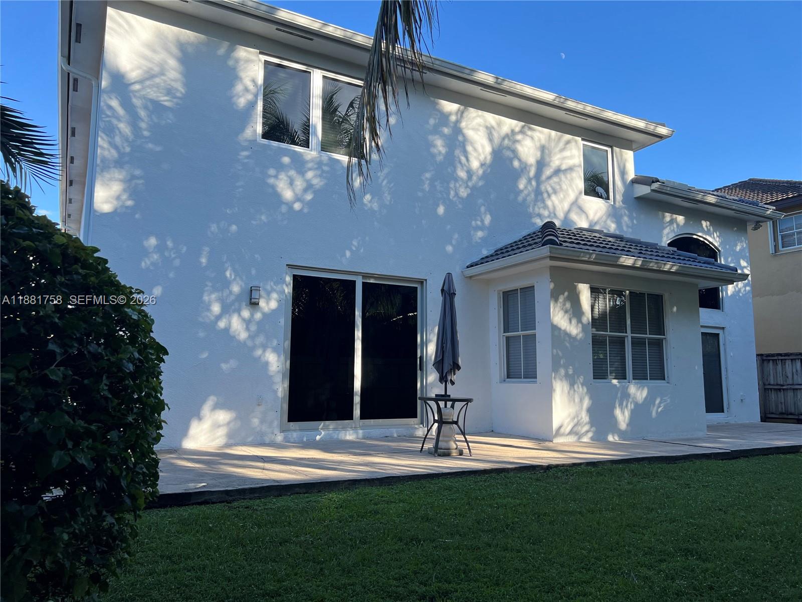 704 Northwest 129th Court Miami, FL 33182 - Photo 52 of 58 a front view of a house with a yard table and chairs