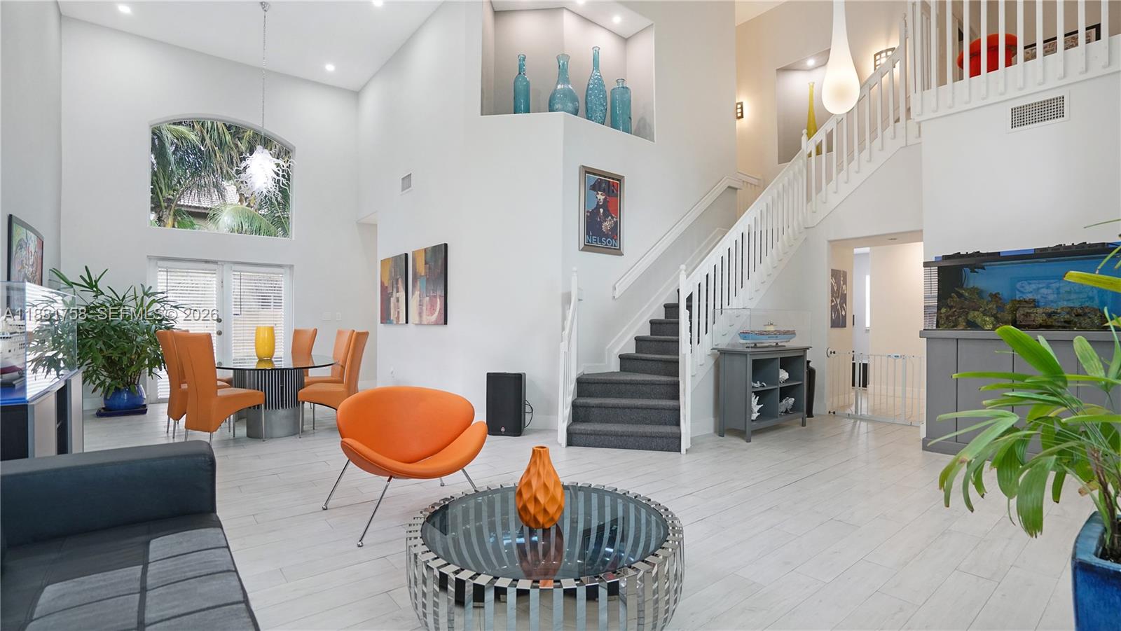 704 Northwest 129th Court Miami, FL 33182 - Photo 6 of 58 a living room with furniture potted plants and a chandelier