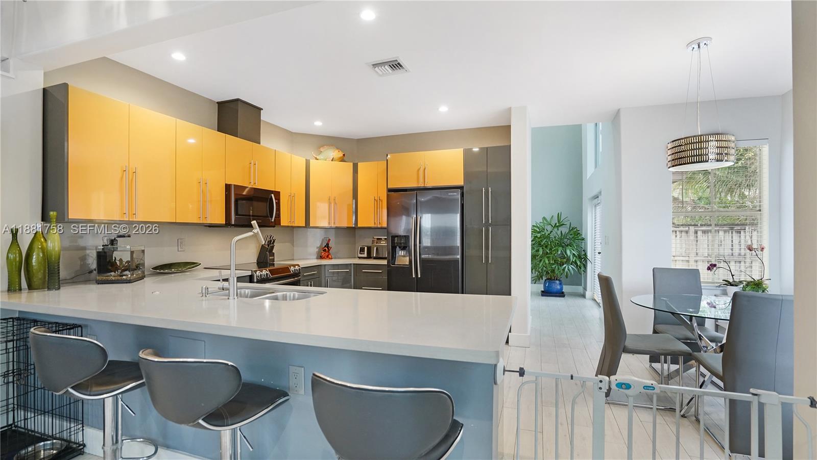 704 Northwest 129th Court Miami, FL 33182 - Photo 10 of 58 a kitchen with a table chairs refrigerator and cabinets