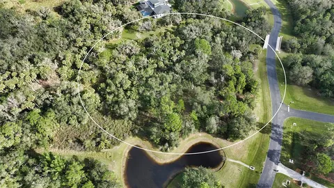 an aerial view of residential houses with outdoor space and trees