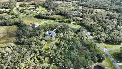 an aerial view of residential house with outdoor space and trees around