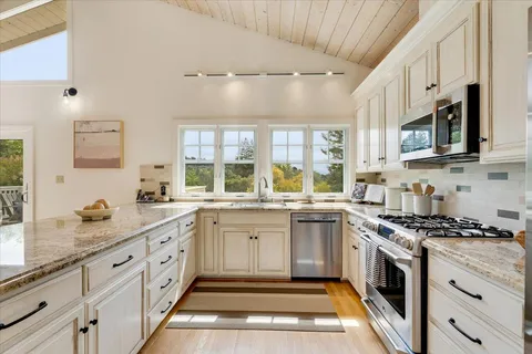 a kitchen with granite countertop a sink stove and cabinets