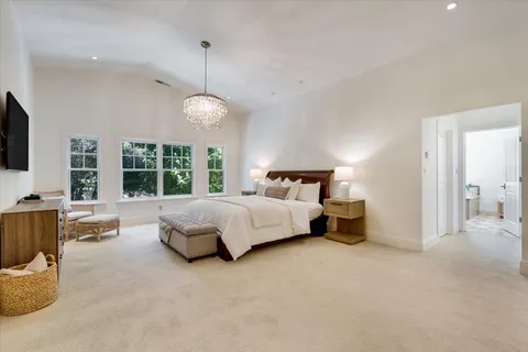 a bedroom with a large bed and a chandelier