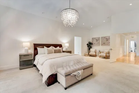 a spacious bedroom with a bed and chandelier
