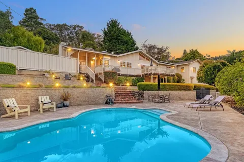 a view of a house with backyard porch and sitting area