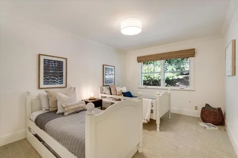 a bedroom with a bed a table and a window