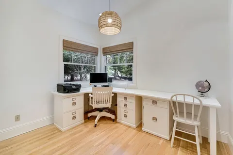 a view of a workspace with furniture and a window