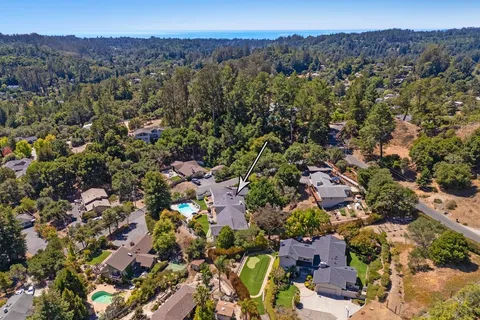 an aerial view of a houses with a street and mountains