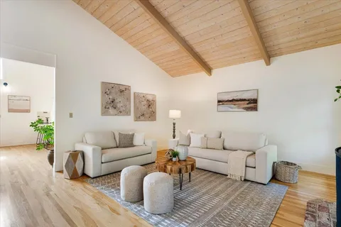 a living room with furniture a rug and a wooden floor