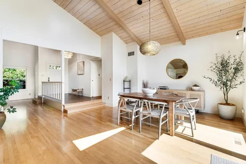 a dining room with wooden floor and chandelier