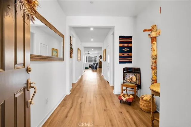 a view of a hallway with wooden floor and furniture