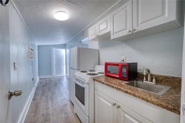 a kitchen with granite countertop a sink a stove and cabinets
