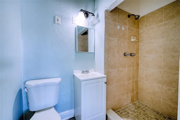 a bathroom with a toilet sink shower and mirror