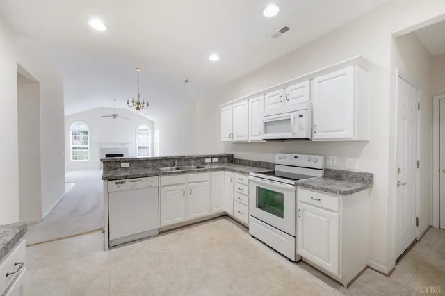 a kitchen with stainless steel appliances granite countertop a stove and white cabinets
