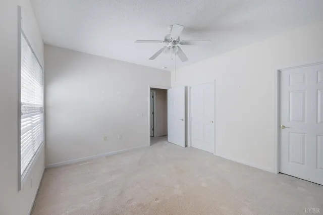 an empty room with fan and windows