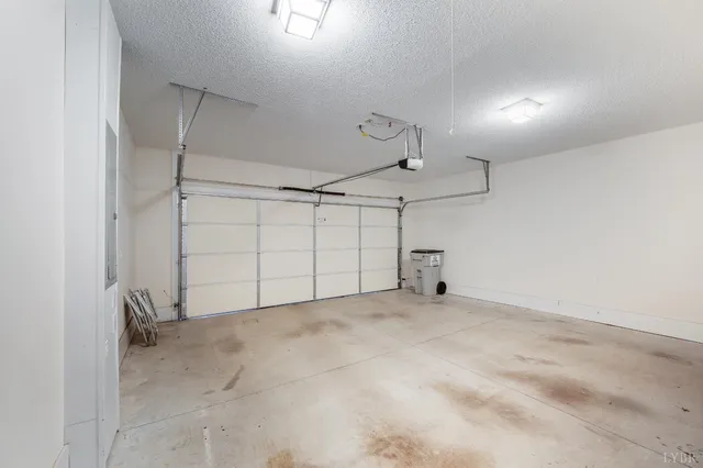 an empty room with chandelier fan and windows