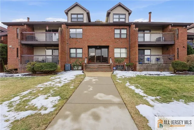 a front view of a residential apartment building with a yard