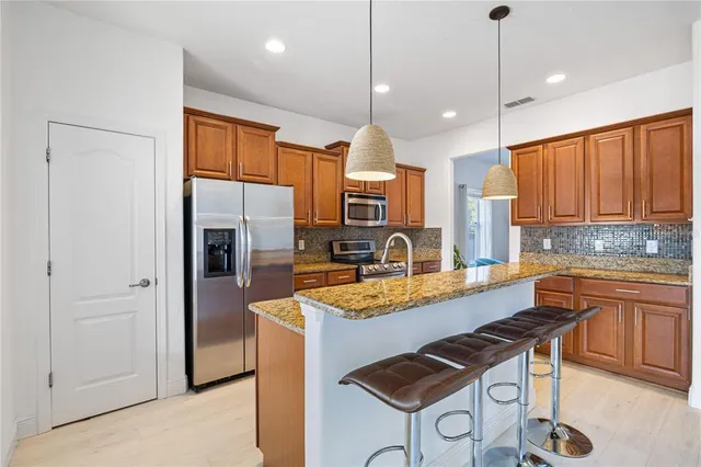 a kitchen with a sink a counter top space and living room view