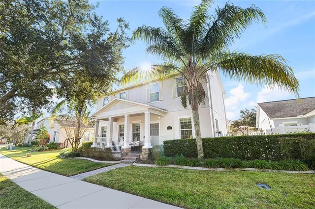 front view of a house with a yard and palm trees