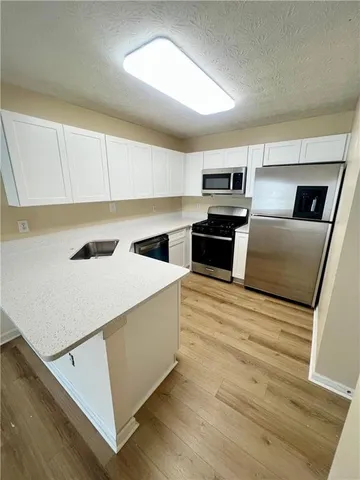 a kitchen with a refrigerator a stove top oven a sink and dishwasher