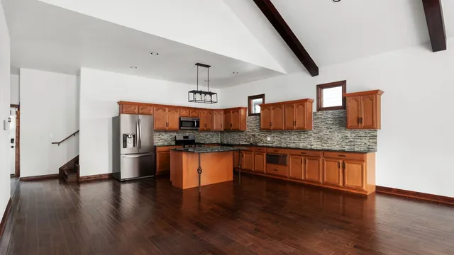 a kitchen with stainless steel appliances granite countertop wooden floors and view living room