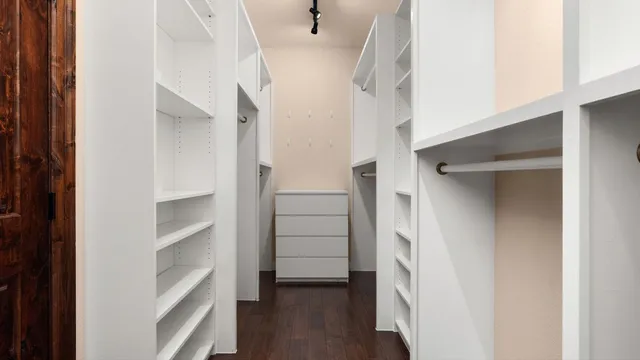 a view of walk in closet with empty racks