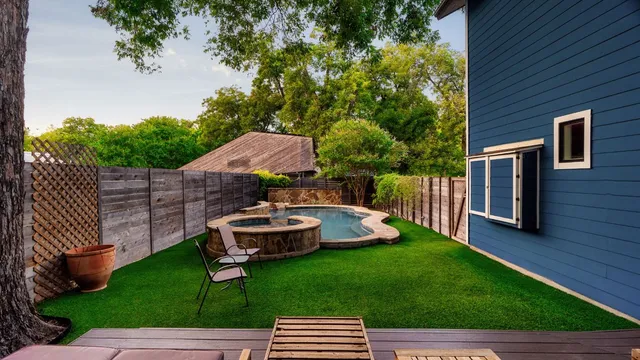 a view of backyard with swimming pool and green space