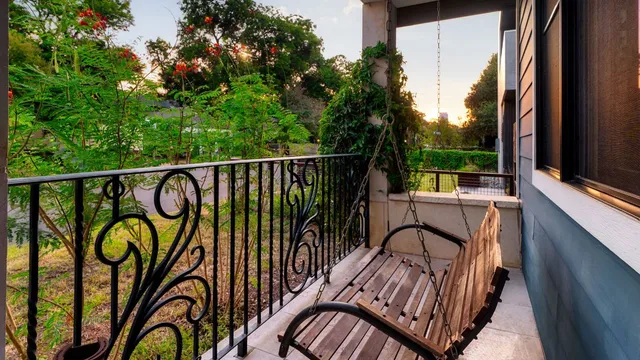 a balcony with couple of chairs and a swing