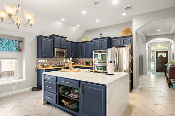 a kitchen that has a lot of cabinets in it and appliances
