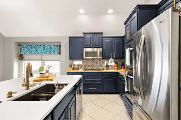 a kitchen with granite countertop a refrigerator and a sink