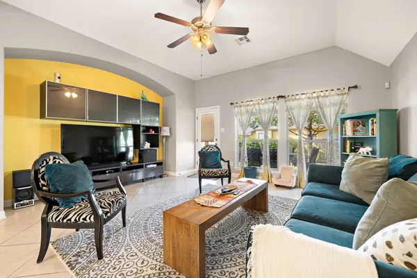 a living room with furniture a flat screen tv and a large window