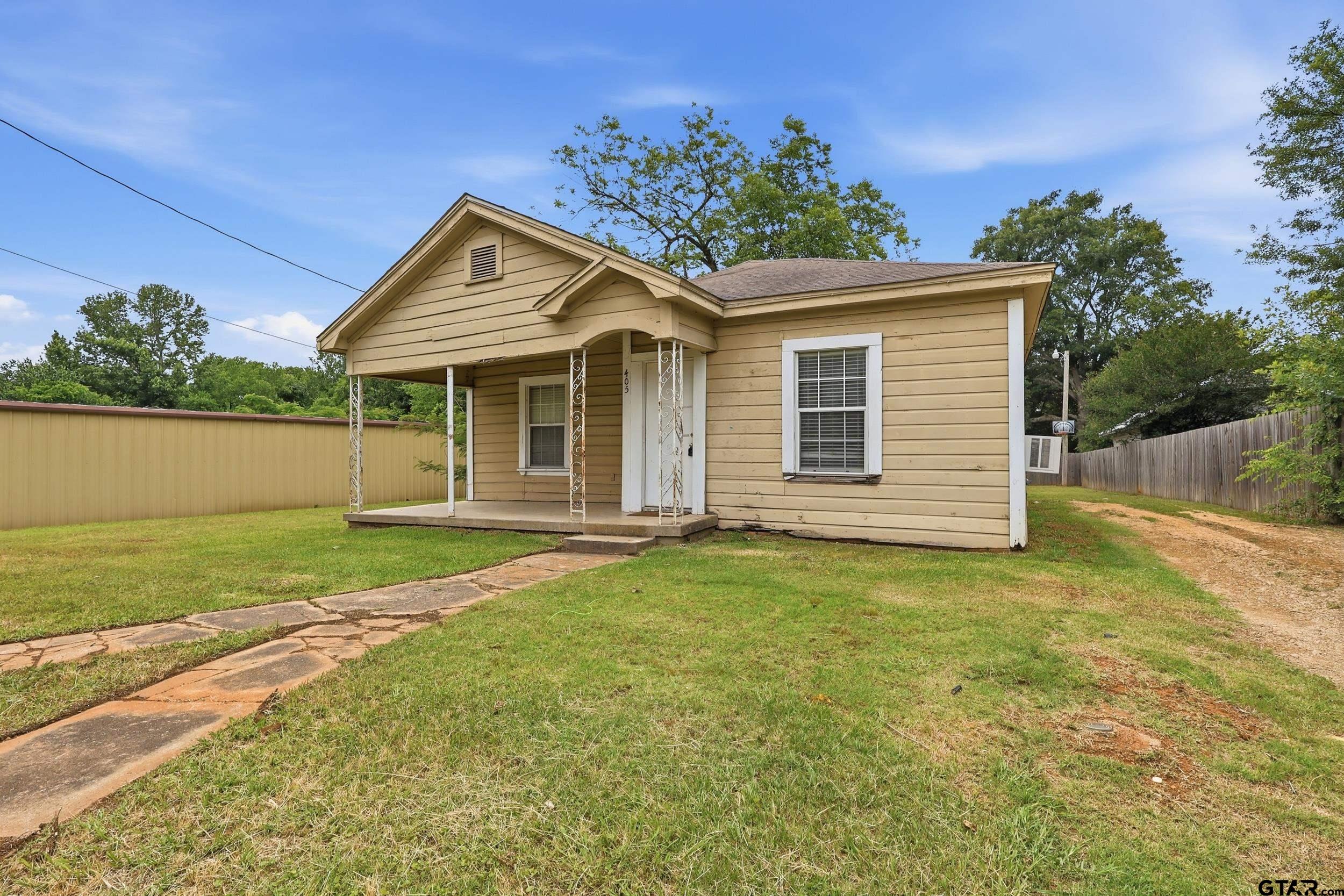 405 Rusk Street Pittsburg, TX 75686 - Photo 5 of 33 a view of a house with a yard and garage