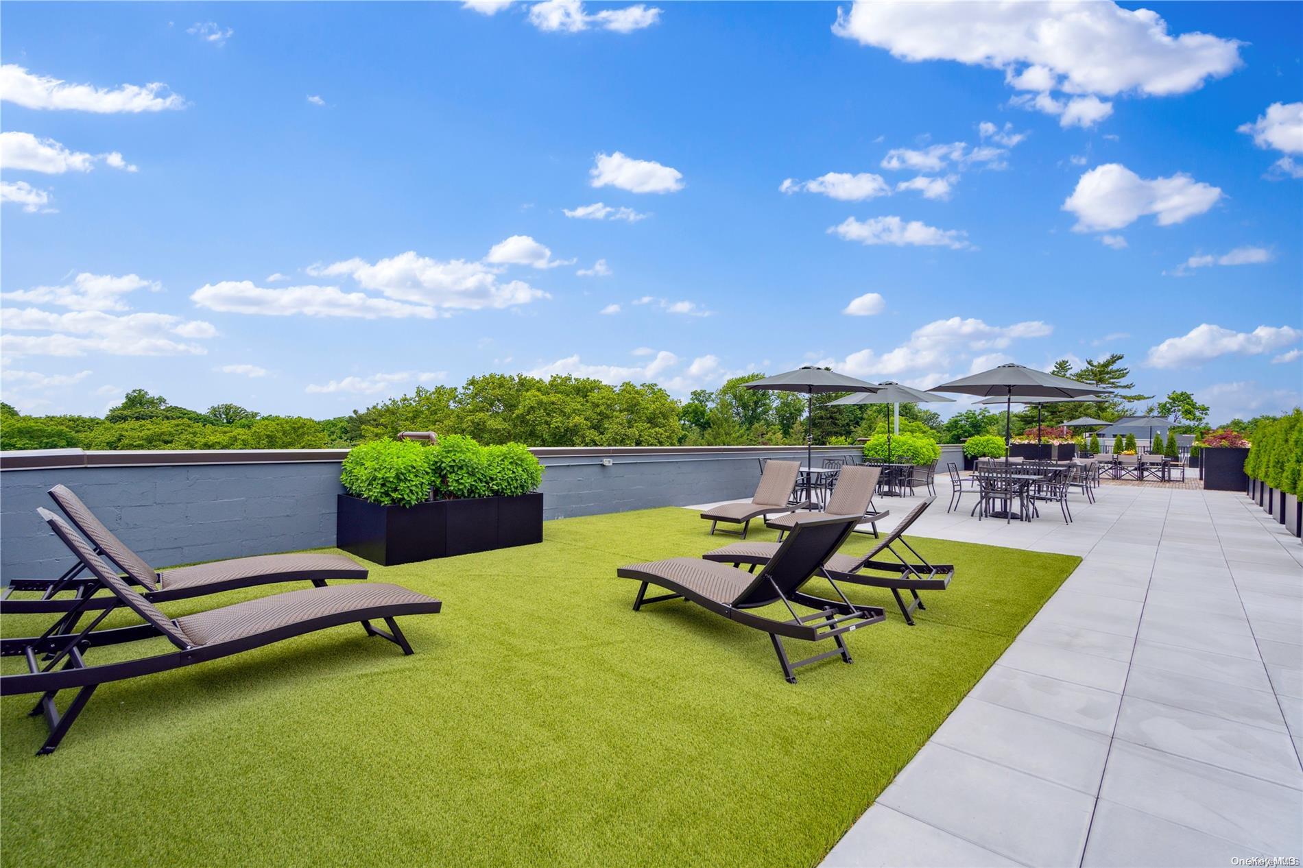 218 Middle Neck Road, Unit 314 Great Neck, NY 11021 - Photo 12 of 23 a swimming pool with outdoor seating and a garden