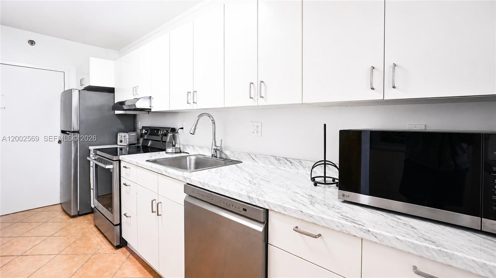 100 Lincoln Road, Unit 1209 Miami Beach, FL 33139 - Photo 5 of 25 a kitchen with stainless steel appliances granite countertop a sink stove and refrigerator