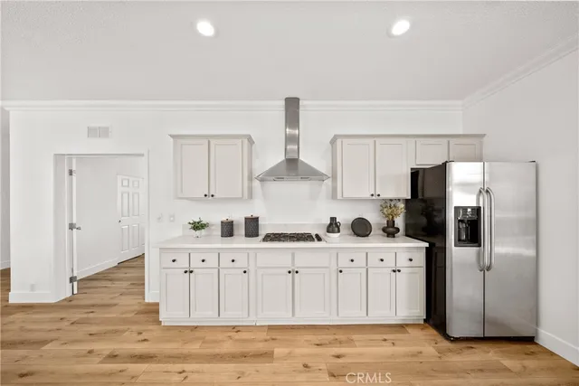 a kitchen with stainless steel appliances a sink a stove a refrigerator and cabinets